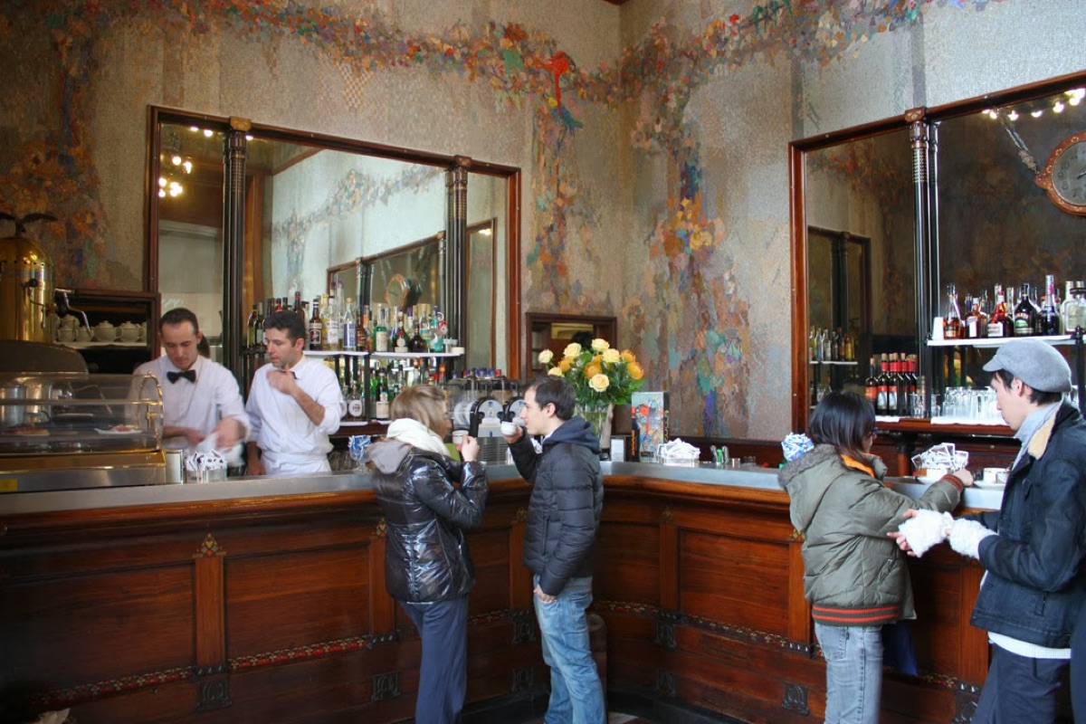 Locals having coffee standing at the counter of a historic Naples cafe