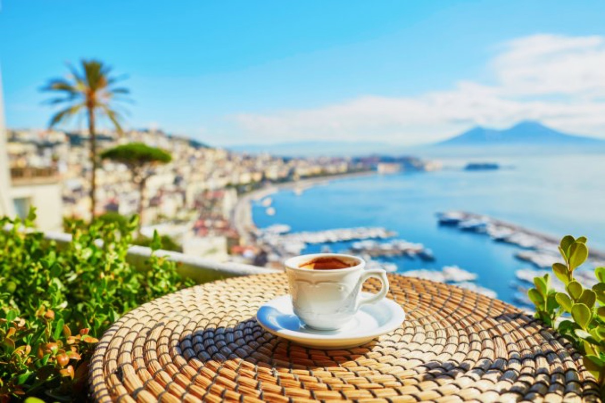 A cup of espresso on a terrace overlooking the Bay of Naples and Vesuvius