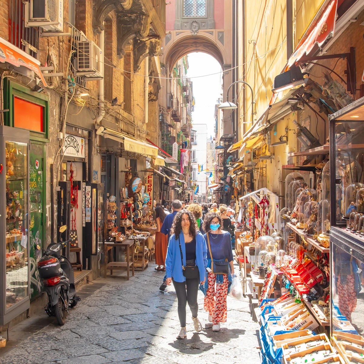 A busy alley in the Centro Storico of Naples under an arch